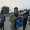 El estudiante muestra un cartel que da a conocer este proyecto